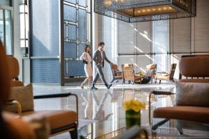 Ein Mann und eine Frau gehen durch eine Lobby in der Unterkunft InterContinental Foshan DongPing in Shunde