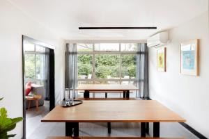 a dining room with a table and a large window at Together Co-Living Melbourne in Melbourne