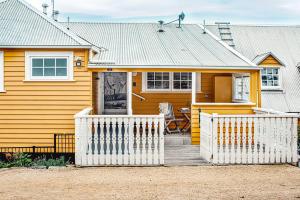 a yellow house with a white fence in front of it at Ship Inn Stanley in Stanley