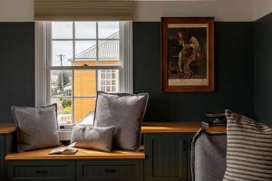 a room with a wooden table with pillows and a window at Ship Inn Stanley in Stanley