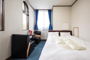 日光市にあるキヌガワ ペンション バンブー のベッドルーム1室(ベッド1台、テーブル、窓付)