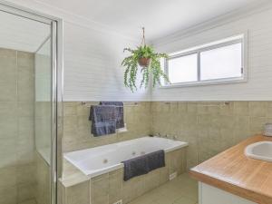 
A bathroom at Sounds by the Sea - open plan living, metres to beach
