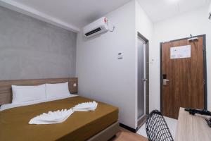a bedroom with a bed with two white sheets at Urban Inn, SP Saujana in Sungai Petani