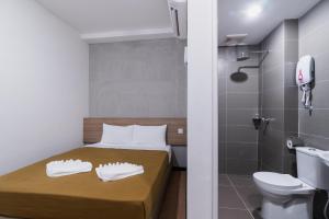 - une petite salle de bains avec un lit et des toilettes dans l'établissement Urban Inn, SP Saujana, à Sungai Petani