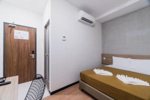 1 dormitorio con 1 cama y puerta de madera en Urban Inn, SP Saujana, en Sungai Petani