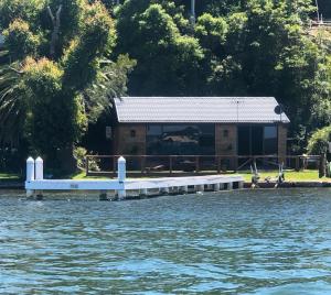 a house on the shore of a body of water at Serenity by the Lake - Romantic Waterfront Couple's Getaway in Marks Point +13 photos