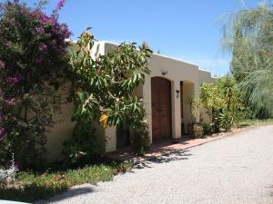 a small white house with a door and some flowers at Belvilla by OYO Casa Lourdes in Sant Miquel de Balansat