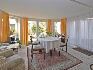 a living room with a white table and chairs at Attractive apartment in Bellenberg with garden in Horn-Bad Meinberg