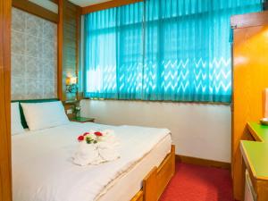 Un dormitorio con una cama con flores. en Siri Hotel, en Nakhon Ratchasima