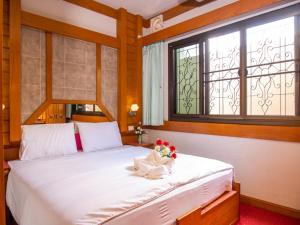 Un dormitorio con una gran cama blanca con flores. en Siri Hotel, en Nakhon Ratchasima