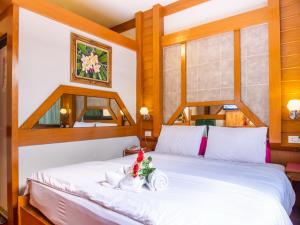 Un dormitorio con una cama blanca con flores. en Siri Hotel, en Nakhon Ratchasima