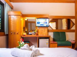 um quarto de hotel com uma cama e uma televisão em Siri Hotel em Nakhon Ratchasima