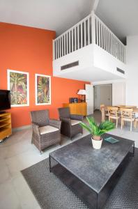 sala de estar con paredes de color naranja y mesa en Cannes Croisette Prestige Apart'hotel, en Cannes