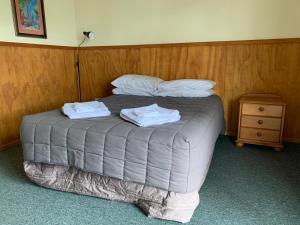 ein Schlafzimmer mit einem Bett mit zwei Handtüchern darauf in der Unterkunft New Central Hotel Woodville in Woodville