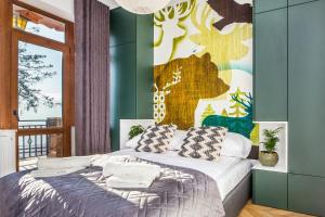 1 dormitorio con 1 cama con un mural en la pared en Apartamenty na Leśnej, en Bukowina Tatrzańska