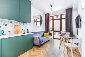 cocina y sala de estar con sofá y mesa en Apartamenty na Leśnej, en Bukowina Tatrzańska