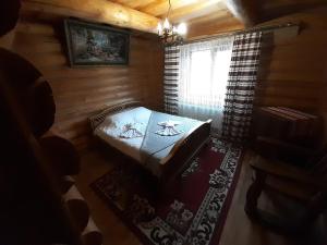 een kleine kamer met een tafel in een blokhut bij Guest House Dikiy Zrub in Vorochta