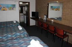 une chambre d'hôtel avec deux lits et un bar avec des chaises dans l'établissement Portland Retro Motel, à Portland