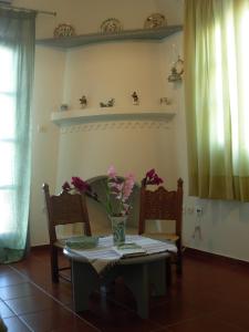 a dining room table with a vase of flowers on it at DIMITRIOS in Skiros