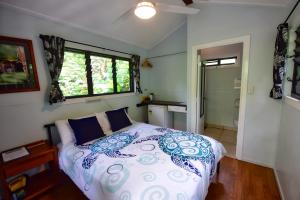 a bedroom with a bed and a window at Thornton Beach Bungalows Daintree in Cape Tribulation