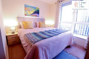 Un dormitorio con una cama grande y una ventana en GREAT VALUE, 2 Bedroom Penthouse Apt at Angel & Ken Serviced Accommodation Woking, en Woking