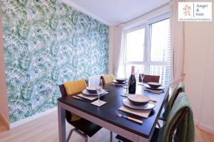 una sala da pranzo con tavolo, sedie e murale di GREAT VALUE, 2 Bedroom Penthouse Apt at Angel & Ken Serviced Accommodation Woking a Woking