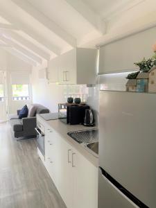 a kitchen with white cabinets and a white refrigerator at Nepean by Gateway Lifestyle Holiday Parks in Penrith