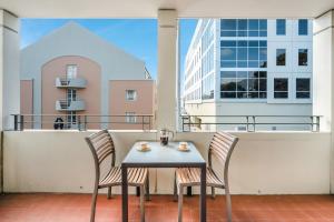 a table and two chairs on a balcony at Jenatt Apartments Salamanca in Hobart