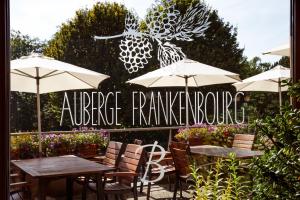 AUBERGE FRANKENBOURG في La Vancelle: فناء في الهواء الطلق مع طاولات وكراسي ومظلات