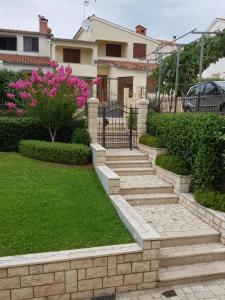 a garden with stone steps and pink flowers in front of a house at Apartment Magnolia in Mušalež