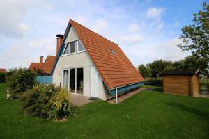 a small white house with an orange roof at SR Nordertill 7 in Dorum Neufeld