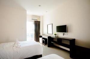 a bedroom with a bed and a desk and a television at วรรณ เพลส Won Place in Khon Kaen