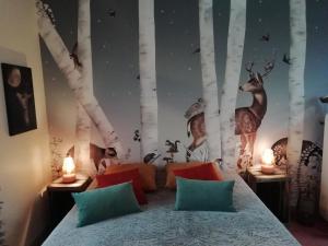 a bedroom with a bed with a mural of trees at La Haute Forge Maison d'Hôtes in Thoiré-sur-Dinan