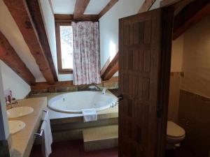 a bathroom with a tub and two sinks and a window at Hosteria del Arco in Pedraza-Segovia