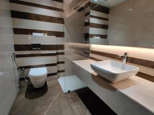 a bathroom with a sink and a toilet at PPH Living Neermala Residency in Coimbatore