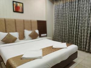 a hotel room with two beds with napkins on them at PPH Living Neermala Residency in Coimbatore