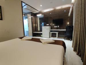 a large white bed in a room with a kitchen at Neermala Residency in Coimbatore