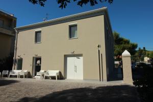 un gran edificio blanco con sillas y una puerta en la casa in Ancona, en Ancona