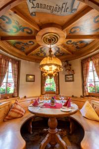 a dining room with a table and a chandelier at Sackmann Wanderhotel in Baiersbronn