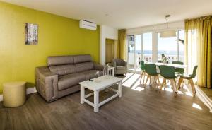 a living room filled with furniture and a table at Apartamentos Perla Marina in Nerja