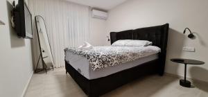 uma cama com uma cabeceira preta num quarto em Yuval holidey aprtment eilat em Eilat