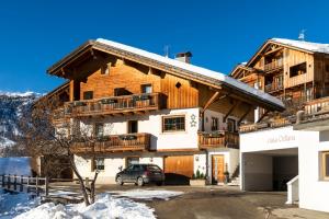 een huis met een auto ervoor geparkeerd bij Ciasa Odlana in San Cassiano