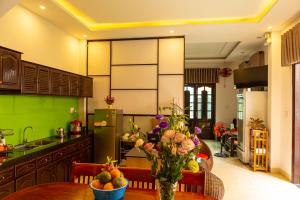 a kitchen with a table with flowers on it at Spring Garden Villa Hoi An in Hoi An