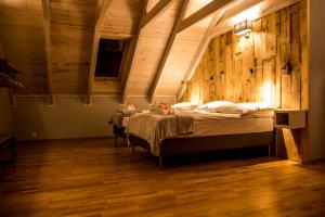 sypialnia z 2 łóżkami w pokoju z drewnianymi ścianami w obiekcie Dyniówka w Cisnej
