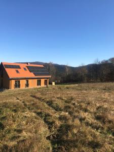 a house with an orange roof in a field at Dyniówka in Cisna