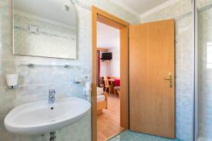 baño con lavabo blanco y habitación en Apartments Puntin, en San Cassiano