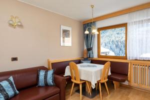 a living room with a couch and a table at Apartments Puntin in San Cassiano