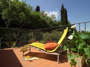 una silla amarilla sentada en un patio junto a una valla en B&B Monte Oliveto, en Florencia
