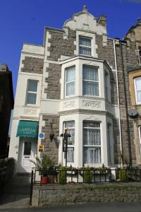 a large stone building with a white at Camellia Lodge Guest House in Weston-super-Mare