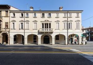 帕多瓦的住宿－Palazzo Bovio - Boutique Apartments，街道上一座大型白色建筑,设有阳台